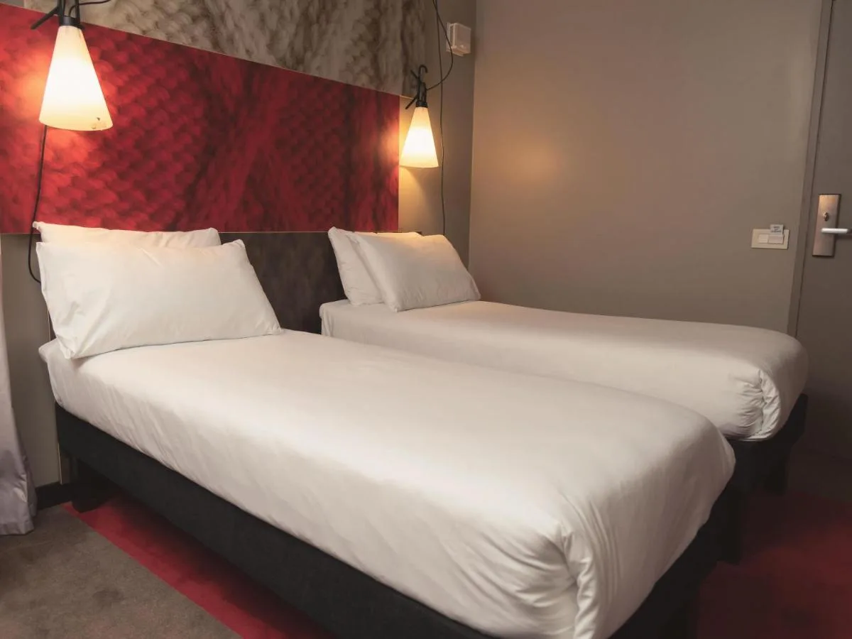 two beds in a hotel room with white sheets at ibis Glasgow City Centre – Sauchiehall St in Glasgow